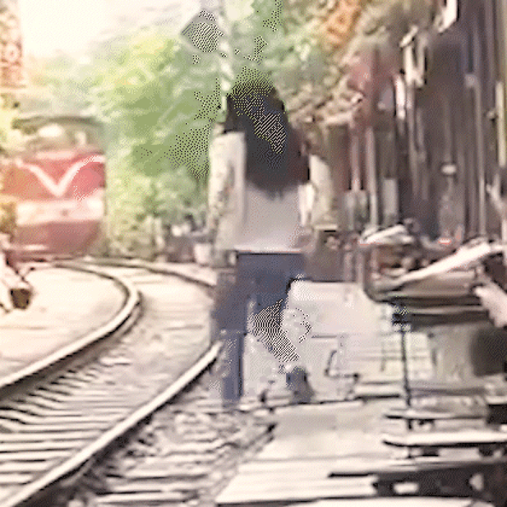 Người đàn ông kịp đẩy cô gái vào phía trong, trước khi tàu hỏa lao tới - Ảnh: HN TV