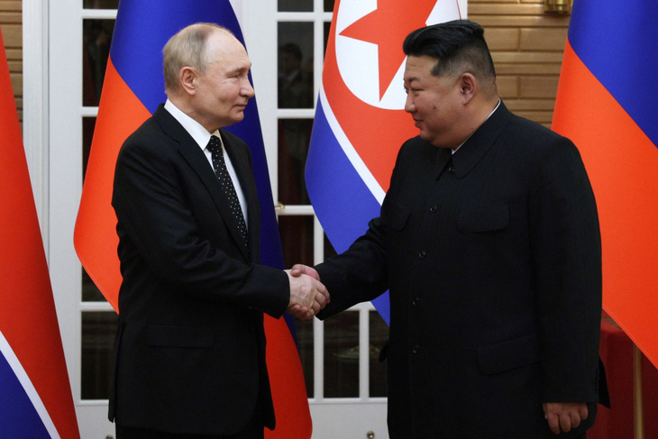Tổng thống Nga Vladimir Putin bắt tay nhà lãnh đạo Triều Tiên Kim Jong Un tại cuộc hội đàm ngày 19-6 - Ảnh: AFP