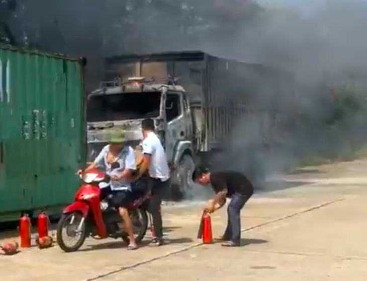 Người dân đưa bình chữa cháy của gia đình đến dập lửa vụ cháy xe tải - Ảnh cắt từ clip