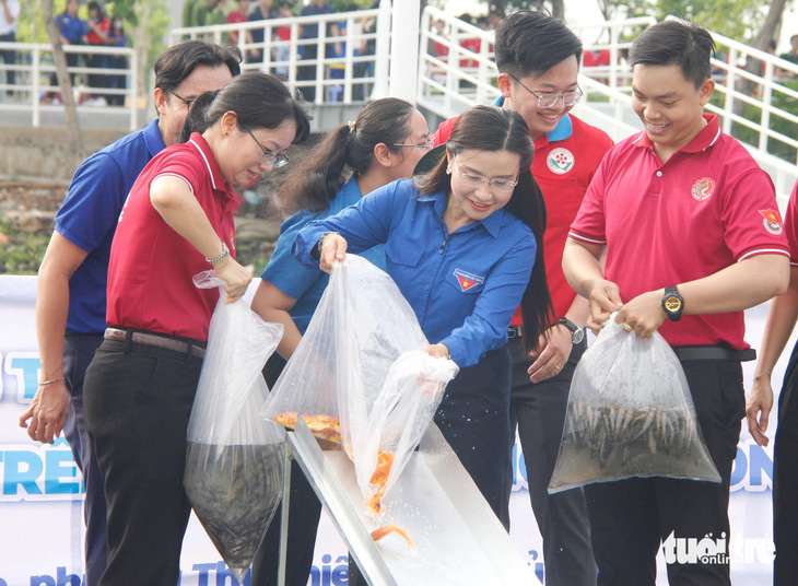 Phó chủ tịch UBND TP.HCM Trần Thị Diệu Thúy và Bí thư Trung ương Đoàn Nguyễn Phạm Duy Trang cùng thả cá giống tại lưu vực sông Sài Gòn - Ảnh: CÔNG TRIỆU