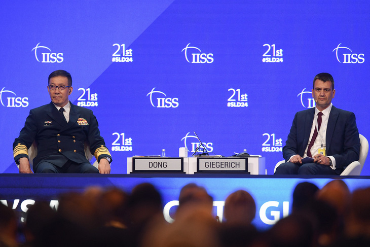 Ông Đổng Quân (trái) trả lời câu hỏi từ phía các đại biểu - Ảnh: AFP