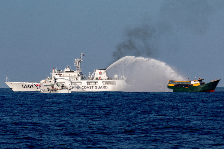 Tàu Hải cảnh Trung Quốc phun vòi rồng về phía tàu Philippines thực hiện nhiệm vụ tiếp tế cho lực lượng đóng tại bãi Cỏ Mây hôm 4-5 - Ảnh: REUTERS