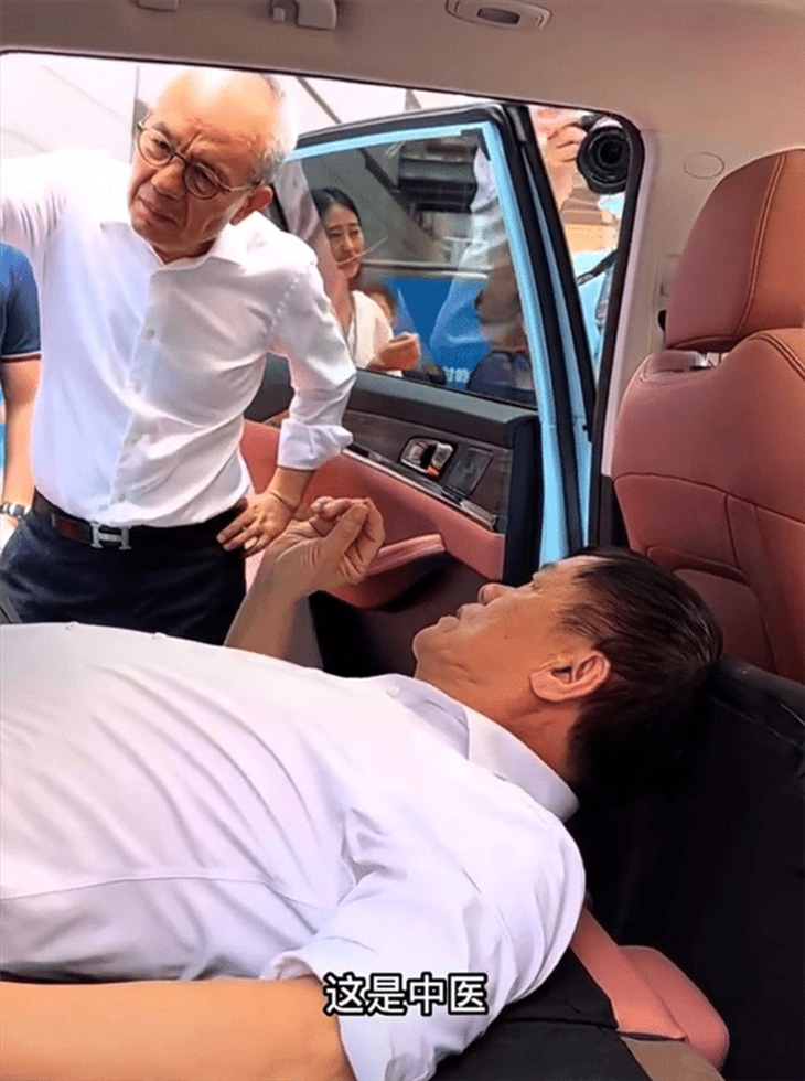 Ông Hoàng Hoành Sinh đang cho thấy ngủ trên xe điện của Skyworth tốt như thế nào. "Phụ đề" trong ảnh là "Đây là Trung dược" ý chỉ dược phẩm Trung y cổ truyền Trung Quốc - Ảnh: Car News China