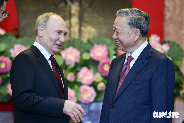 Chủ tịch nước Tô Lâm và Tổng thống Putin trao đổi khi chụp ảnh chung - Ảnh: NAM TRẦN