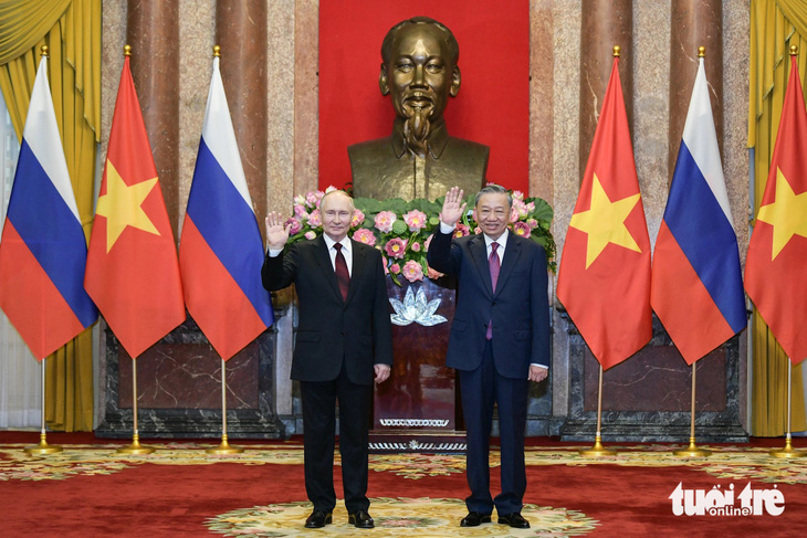 Chủ tịch nước Tô Lâm và Tổng thống Putin vẫy tay chào báo chí khi chụp ảnh chung - Ảnh: NAM TRẦN