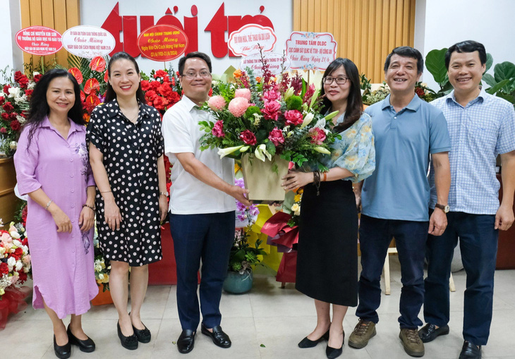 Ông Nguyễn Việt Hùng - giám đốc Sở Thông tin và Truyền thông Hà Nội - tặng hoa chúc mừng lãnh đạo Văn phòng báo Tuổi Trẻ tại Hà Nội - Ảnh: HÀ QUÂN