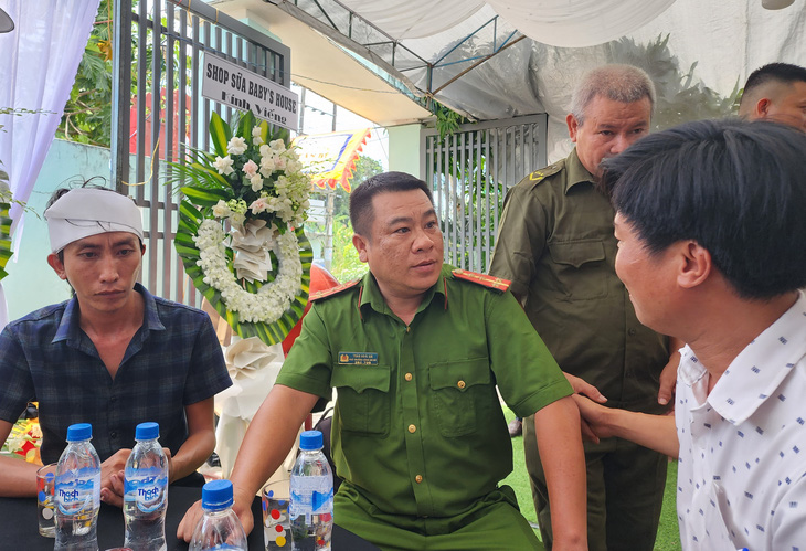 Đại úy Trần Hoài An, phó trưởng Công an xã Nghĩa Dõng, tới lui động viên gia đình nạn nhân - Ảnh: TRẦN MAI