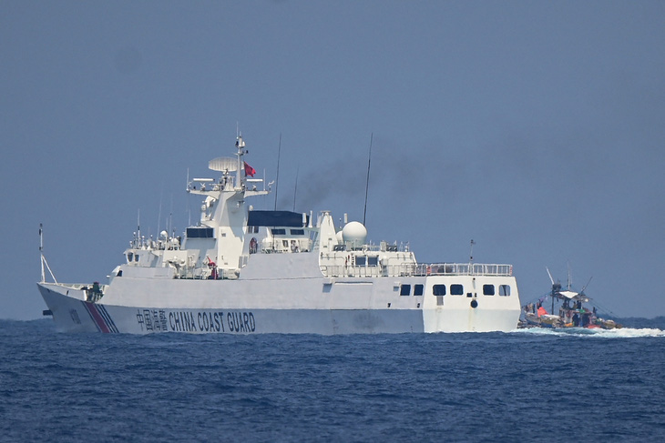 Tàu hải cảnh Trung Quốc di chuyển ngang qua tàu đánh cá Philippines ở Biển Đông, ngày 16-5-2024 - Ảnh: AFP
