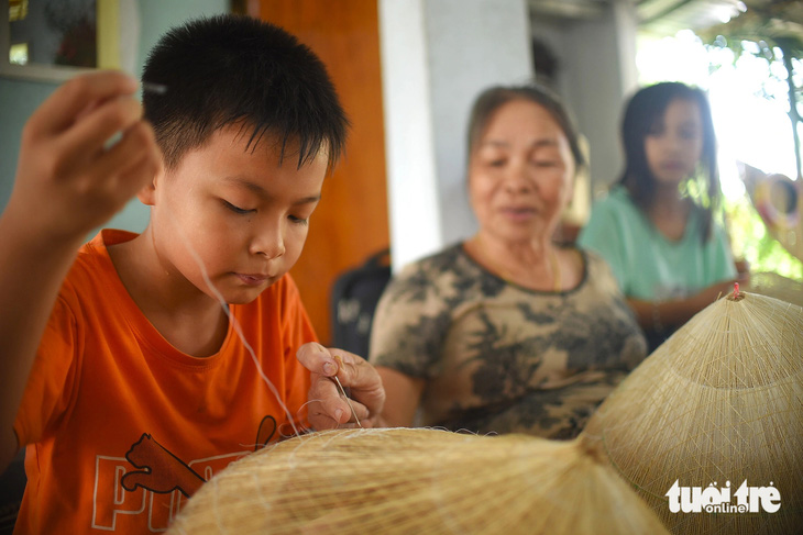 Bà Nguyễn Thị Tâm (73 tuổi, vợ ông Lan) dạy các cháu cách làm nón ngựa
