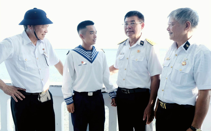 Thượng tá Phạm Văn Hưng (thứ hai, từ phải qua) cùng đồng đội tàu HQ-505 trò chuyện với bạn lính trẻ trên đảo Cô Lin - Ảnh: HÀ THANH