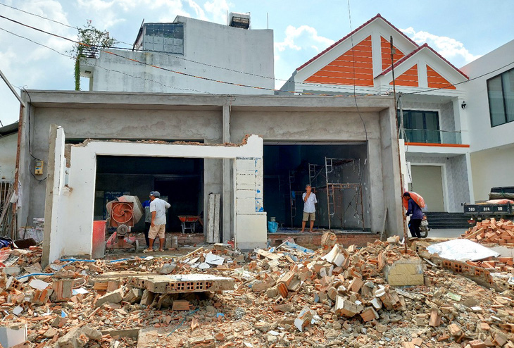 Các hộ dân trên đường Nguyễn Thị Định đồng loạt dỡ nhà, bàn giao mặt bằng để làm đường - Ảnh: GIAI THỤY