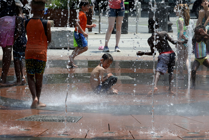 Trẻ em chơi đùa trong một đài phun nước giữa nắng nóng ở TP Boston, bang Massachusetts, Mỹ hôm 19-6 - Ảnh: REUTERS