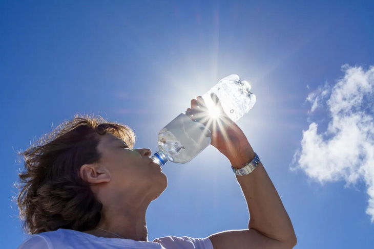 Uống nước đóng chai dưới ánh nắng Mặt trời - Ảnh: Shutterstock