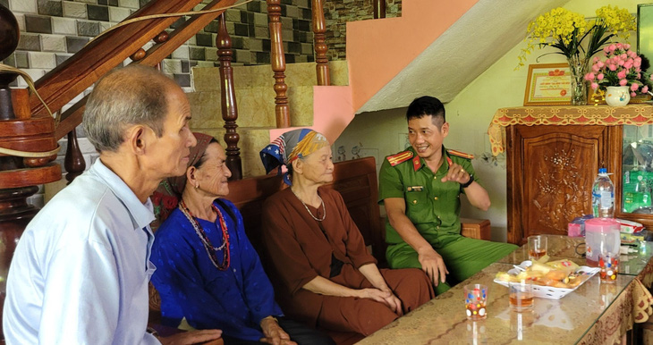 Trung tá Rin vui vẻ trò chuyện với bà Thắm và gia đình ông Hích, người công an này cũng thấy hạnh phúc khi giúp được gia đình đoàn tụ - Ảnh: THANH SU