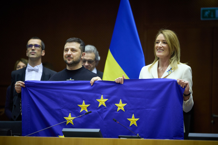 Tổng thống Ukraine Volodymyr Zelensky và Chủ tịch Nghị viện châu Âu Roberta Metsola cùng cầm cờ EU khi ông Zelensky đến phát biểu tại thượng đỉnh khối này hồi tháng 2-2023 - Ảnh: X/VOLODYMYR ZELENSKY