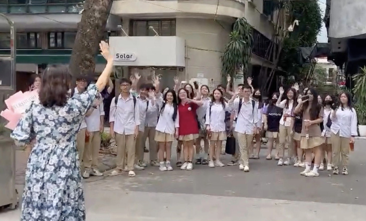 Cô Dương Mai Hương - giáo viên Trường THPT Phan Huy Chú, Hà Nội - vẫy tay tiễn học trò ở cổng trường sau tiết học cuối cùng - Ảnh: NVCC