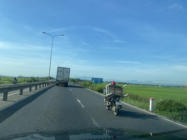 Xe máy của người dân phải di chuyển chung với làn xe tải trên quốc lộ 1 đoạn qua huyện Thăng Bình, Quảng Nam - Ảnh: B.D.