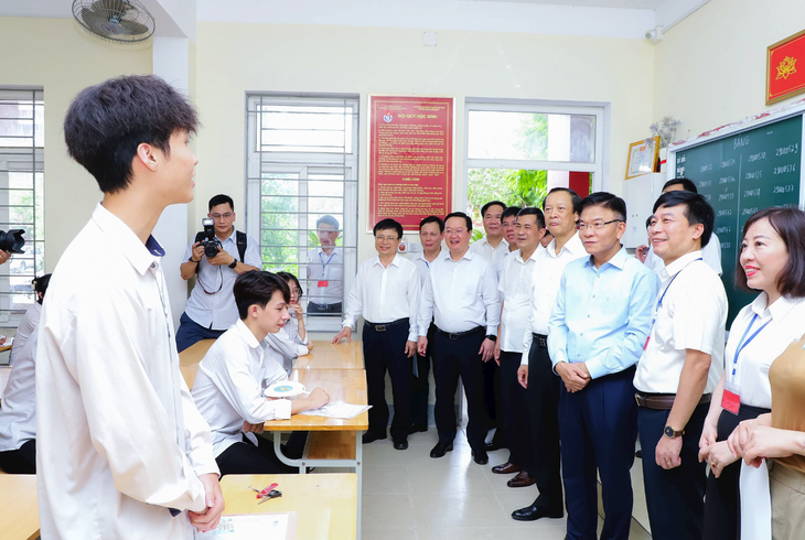 Phó thủ tướng Lê Thành Long lắng nghe chia sẻ của học sinh dự thi tại điểm thi Trường THPT Huỳnh Thúc Kháng, TP Vinh - Ảnh: BẰNG PHẠM