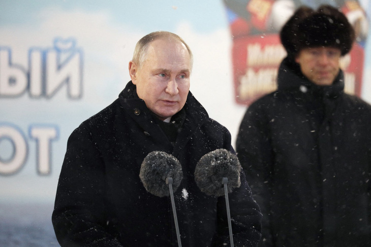 Tổng thống Nga Putin phát biểu dưới tuyết tại lễ chào cờ trong buổi hạ thủy hai tàu ngầm hạt nhân tháng 12-2023 - Ảnh: AFP