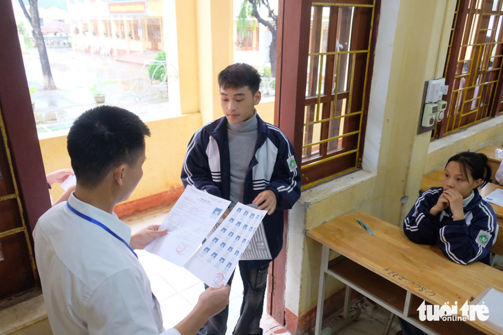Thí sinh tại điểm thi Trường THPT số 1 Bắc Hà (Lào Cai) làm thủ tục vào phòng làm bài thi môn ngữ văn. Do trời mưa và lạnh, nhiều thí sinh mặc áo khoác giữ ấm trong phòng thi - Ảnh: NGUYÊN BẢO