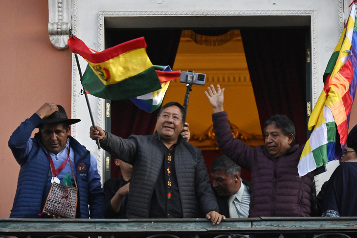 Tổng thống Bolivia Luis Arce (giữa) vẫy cờ với những người ủng hộ ông từ Phủ Tổng thống ngày 26-6 - Ảnh: AFP