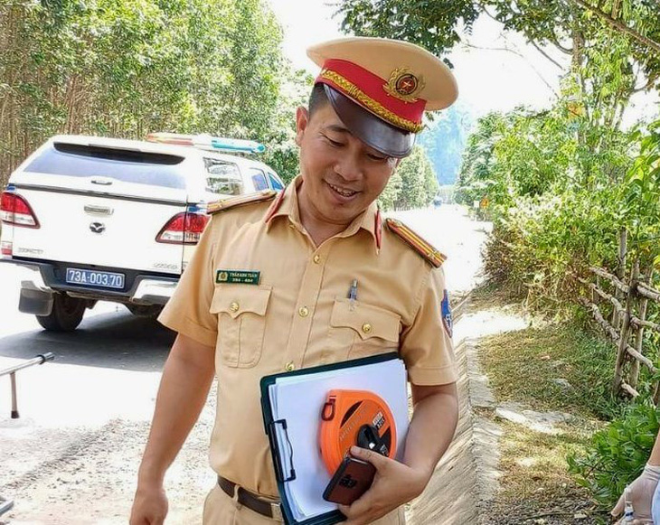 Hình ảnh anh Trần Anh Tuấn, cảnh sát giao thông Quảng Bình, tại thời điểm giúp thuê xe cứu thương đưa em Sỹ đi cấp cứu - Ảnh: LÊ NHÀN