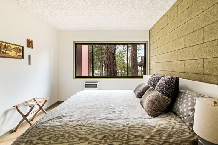 Phòng ngủ phụ với cửa sổ nhìn ra khu rừng thông - Ảnh: dwell