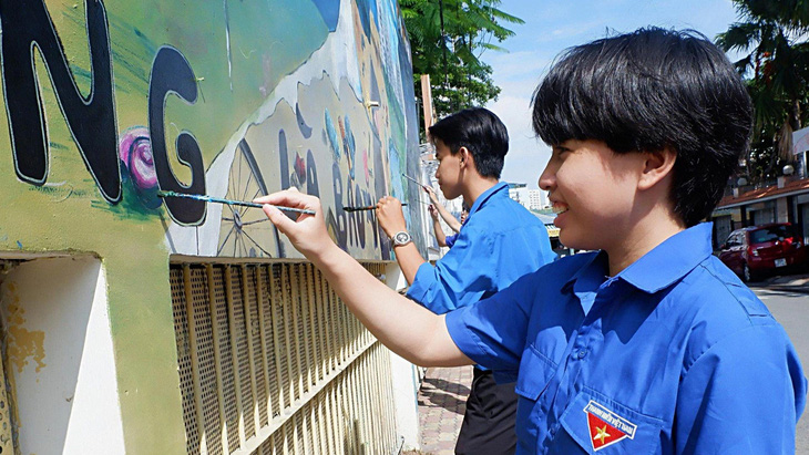 Các bạn sinh viên vẽ tranh tường trang trí với thông điệp kêu gọi ý thức giữ gìn môi trường sống - Ảnh: K.ANH