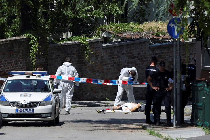Ảnh chụp gần Đại sứ quán Israel ở Serbia ngày 29-6 cho thấy một thi thể trên mặt đất, trong khi cảnh sát canh gác khu vực sau vụ tấn công - Ảnh: REUTERS