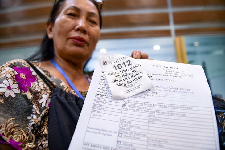Người dân xếp hàng lấy phiếu và điền thông tin chờ giao dịch tại Ngân hàng Agribank 2 Láng Hạ - Ảnh: NAM TRẦN