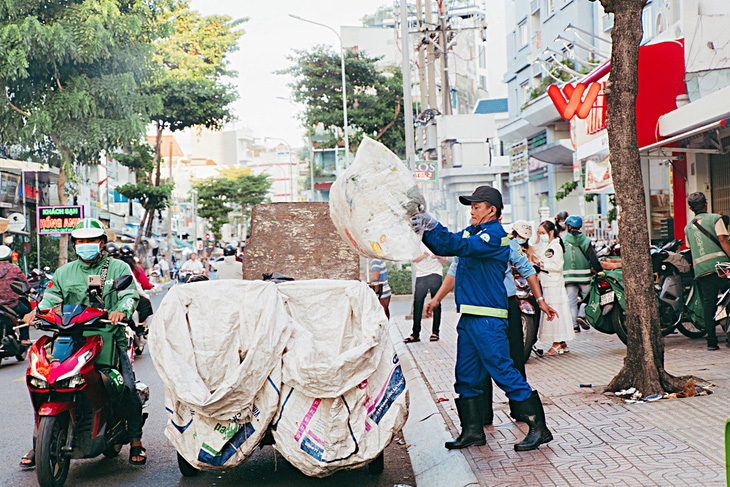Nhân viên công ích thu dọn rác định kỳ trên đường Nguyễn Phúc Nguyên, quận 3 - Ảnh: THANH HIỆP