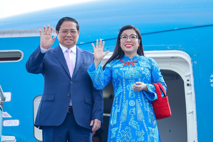Thủ tướng Phạm Minh Chính và phu nhân vẫy tay chào khi lên chuyên cơ - Ảnh: NHẬT BẮC