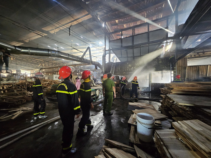 Lực lượng cảnh sát phòng cháy chữa cháy và cứu hộ cứu nạn Công an tỉnh Bình Định khống chế đám cháy xưởng gỗ rộng hàng ngàn m2 - Ảnh: CHÂU THỊ