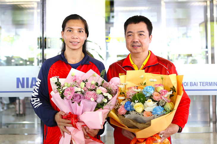 Võ sĩ Hà Thị Linh và HLV Nguyễn Như Cường - người trực tiếp huấn luyện cô giành vé đến Olympic Paris - về đến sân bay Nội Bài ngày 3-6 - Ảnh: HOÀNG TÙNG