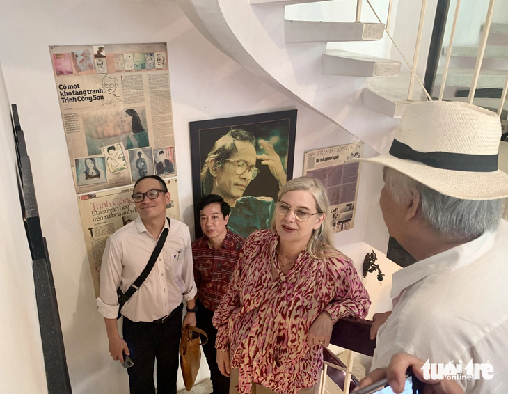 Đại sứ Ann Mawe ngắm những bức hình về cố nhạc sĩ Trịnh Công Sơn được treo dọc theo cầu thang bộ - Ảnh: HOÀI PHƯƠNG