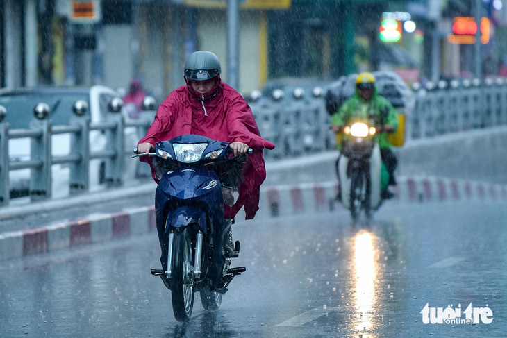 Việc có thêm một đôi giày, dép đi mưa sẽ giúp di chuyển trong mưa an toàn hơn - Ảnh: Tuổi Trẻ Online