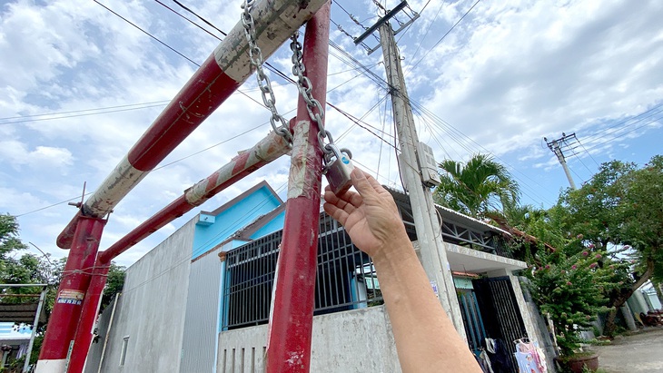 Cổng rào bằng sắt được khóa lại, mỗi hộ dân có xe ô tô được giao chìa khóa riêng ở thôn Thanh Quýt 3
