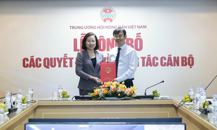 Bà Bùi Thị Thơm, phó chủ tịch Ban chấp hành Trung ương Hội Nông dân Việt Nam, trao quyết định bổ nhiệm cho nhà báo Nguyễn Văn Hoài - Ảnh: PHẠM HƯNG