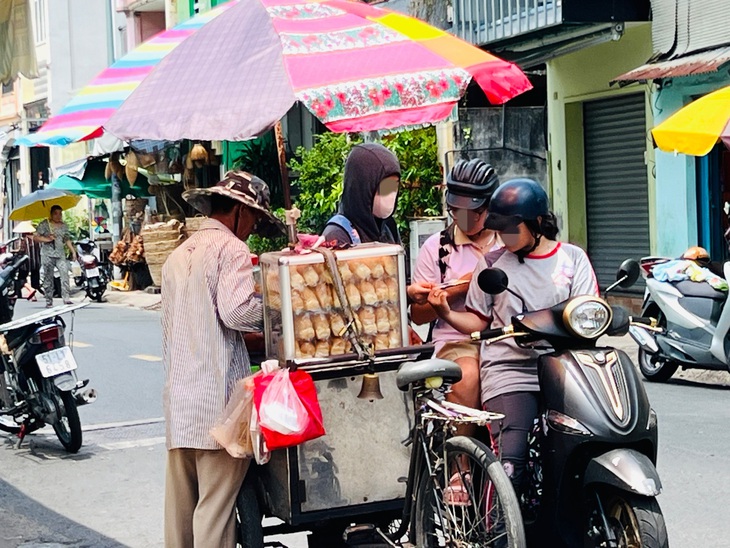 Một cô gái phát tờ rơi tại điểm thi trường THCS B. quận 6&nbsp;
