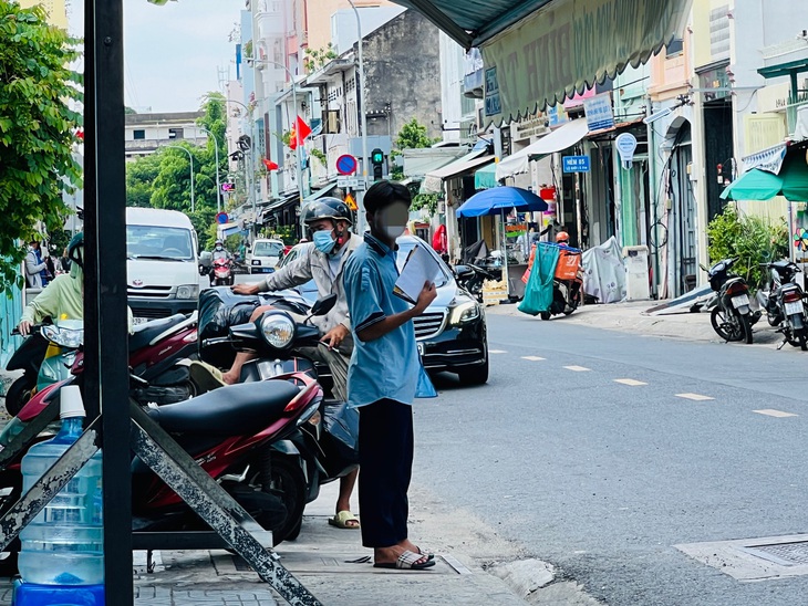 Một học sinh dùng tờ rơi quạt cho mát sau khi kết thúc phần thi buổi sáng&nbsp;