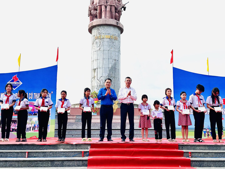 Ông Nguyễn Lưu Trung (áo trắng) - phó chủ tịch UBND tỉnh Kiên Giang - tặng quà cho các em học sinh ở địa phương - Ảnh: THANH SƠN