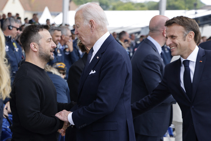 Tổng thống Mỹ Joe Biden bắt tay Tổng thống Ukraine Volodymyr Zelensky trong buổi lễ kỷ niệm quốc tế tại bãi biển Omaha, nhân dịp 80 năm ngày D-Day - Ảnh: AFP