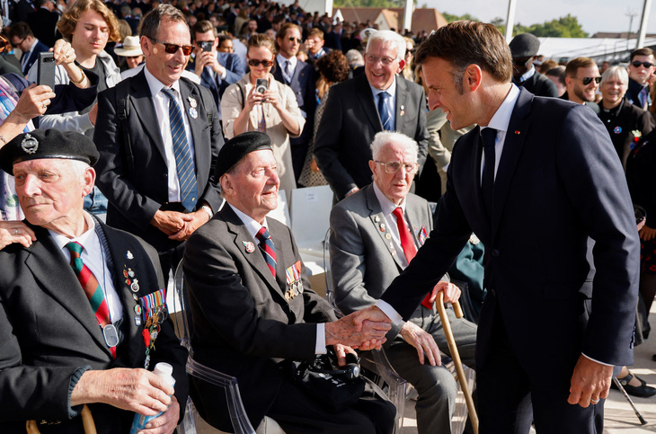 Tổng thống Pháp Emmanuel Macron bắt tay với các cựu chiến binh - những người lưu giữ ký ức cuối cùng về cuộc đổ bộ lớn nhất lịch sử, ngày 6-6 - Ảnh: AFP