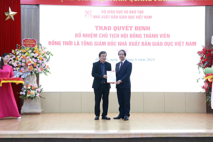 Ông Nguyễn Tiến Thanh (trái) nhận quyết định bổ nhiệm chức tổng giám đốc, chủ tịch hội đồng thành viên Nhà xuất bản Giáo Dục Việt Nam, do Bộ trưởng Bộ Giáo dục và Đào tạo Nguyễn Kim Sơn trao - Ảnh: NXBGDVN