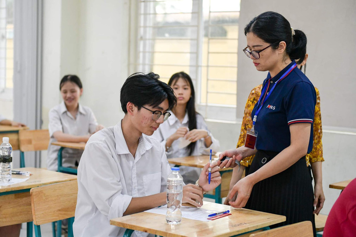 Nhiều thí sinh tại điểm thi trường THCS Mễ Trì, Nam Từ Liêm, Hà Nội được yêu cầu tháo đồng hồ thông minh và các thiết bị không được mang vào phòng thi - Ảnh: NAM TRẦN