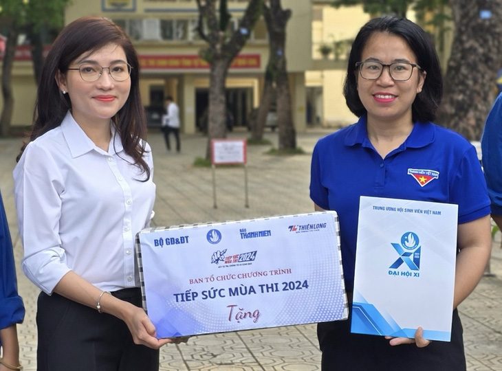 Chị Hồ Hồng Nguyên (trái) - trưởng ban thanh niên trường học Trung ương Đoàn, phó chủ tịch thường trực Trung ương Hội Sinh viên Việt Nam - trao hỗ trợ cho các đội hình tình nguyện Tiếp sức mùa thi ở Hà Nội - Ảnh: HSV