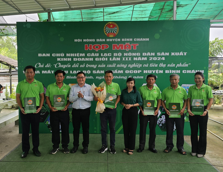 Bà Khưu Thị Diễm Phượng, chủ tịch Hội Nông dân huyện Bình Chánh, tặng hoa chúc mừng ban chủ nhiệm câu lạc bộ - Ảnh: N.T.