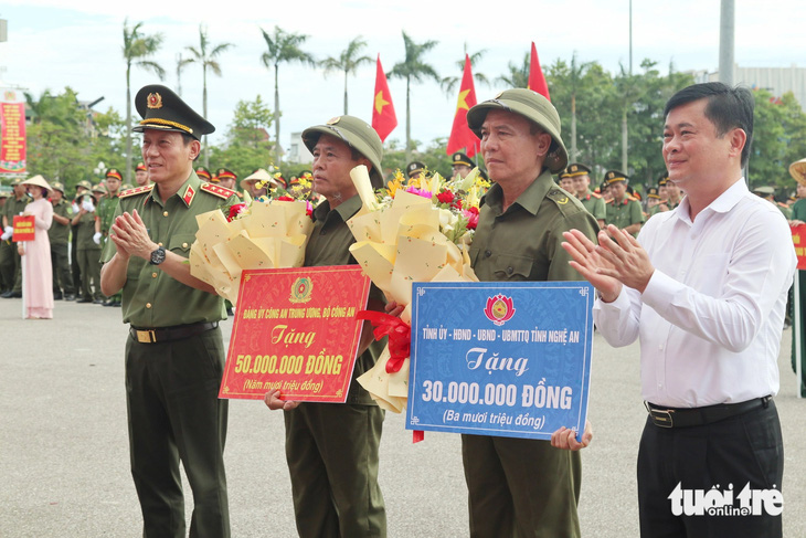 Thượng tướng Lương Tam Quang - bộ trưởng Bộ Công an và ông Thái Thanh Quý - bí thư Tỉnh ủy Nghệ An - tặng quà động viên lực lượng tham gia bảo vệ an ninh, trật tự tại cơ sở - Ảnh: DOÃN HÒA