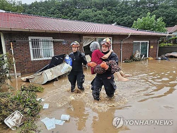 Tại khu vực Wanju thuộc tỉnh Jeolla Bắc, lực lượng cứu hộ đã sơ tán 18 dân làng bị mắc kẹt do nước dâng cao, một số người đang chờ trợ giúp trên mái nhà - Ảnh: YONHAP