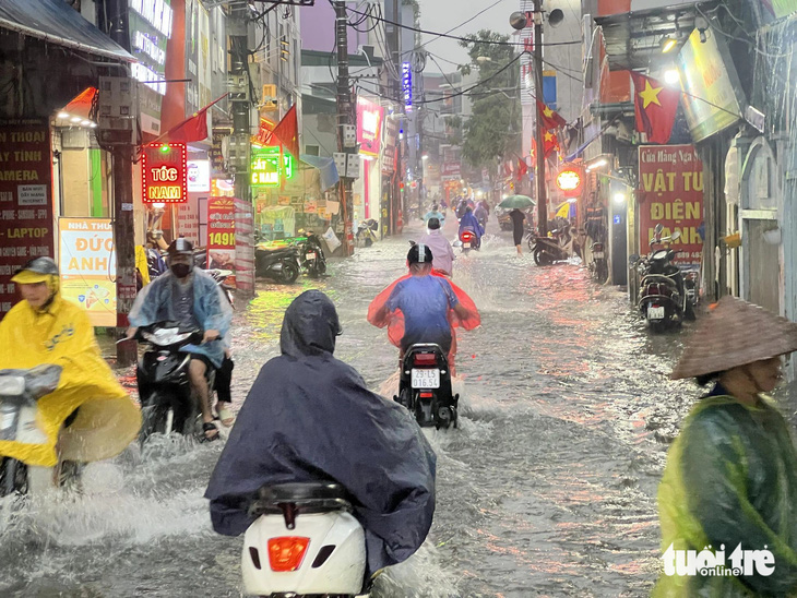 Tuyến đường Xuân Đỉnh ngập úng kéo dài hàng trăm mét, sâu 20-30cm - Ảnh: PHẠM TUẤN